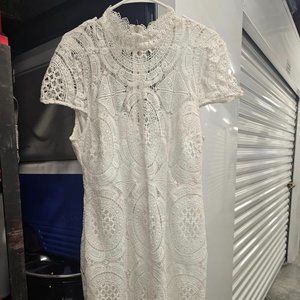 Crafted from delicate lace fabric, this dress exudes femininity and grace. The c